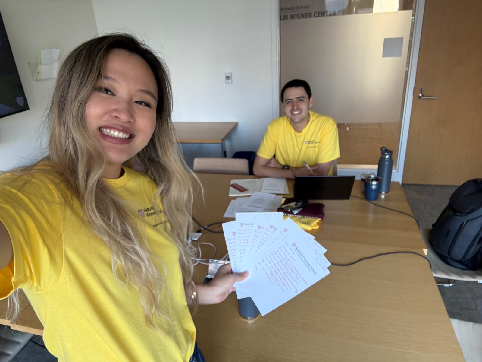 Xinyi holding handwritten welcome notes with a fellow Orientation Leader