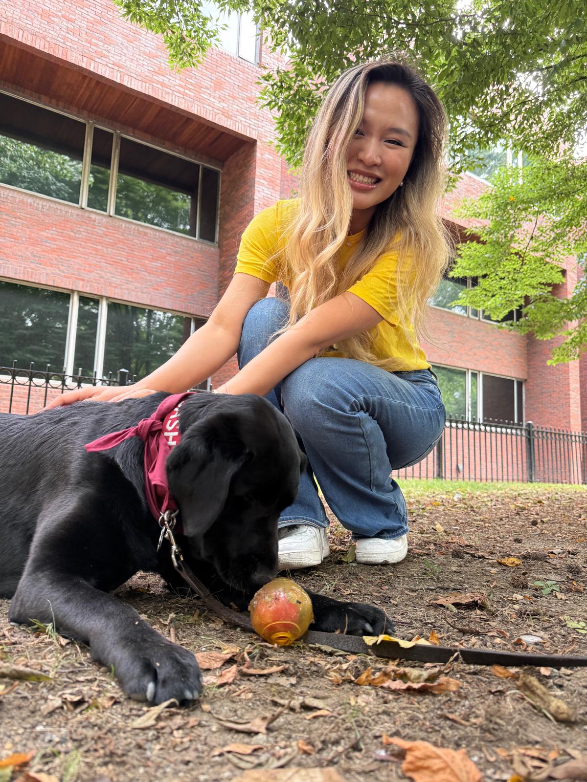 Xinyi in her orientation tee with Sasha, a therapy dog, on the HKS grounds
